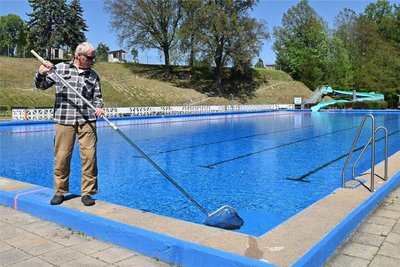 Schwimmmeister Lutz Porsche fischt im Geringswalder Freibad Blütenblätter aus dem Becken. Im Bad sind die Saisonvorbereitungen zum großen Teil abgeschlossen.