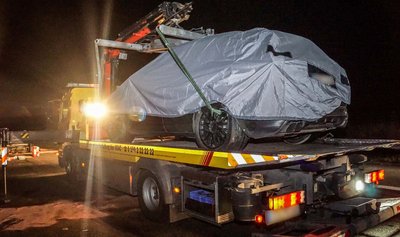 Das Porsche-Testfahrzeug wird nach einem schweren Unfall abgedeckt auf der Autobahn 81 bei Rottenburg (Baden-Württemberg) auf einen Abschleppwagen gehoben. 