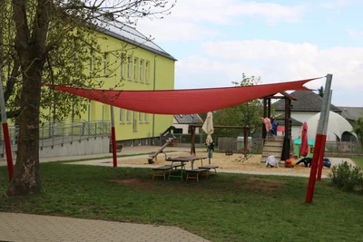Der überdachte Spielplatz hinter dem Haus.
