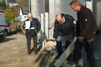 Symbolisch schlug Rolf Mittag (Mitte), der Schatzmeister des DRK-Kreisverbands, einen Nagel ein.
