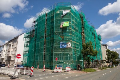 Können die Sicherungsnetze und Gerüste am ehemaligen „Möbel-Spranger“ an der Friedensstraße weg? Die Handwerker wissen es nicht. Dabei bräuchten sie die Konstruktionen dringend.