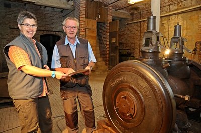Eva Lorenz vom Landesamt für Archäologie erkundigt sich bei Hans-Jürgen Schmiedchen nach dem Wiederaufbau der alten Dampfmaschine.