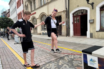 Laura Könnecke (23) aus Chemnitz hat in Freiberg das erste Mal eine Slackline ausprobiert. Ihr Freund stützt sie. Sie ist begeistert.