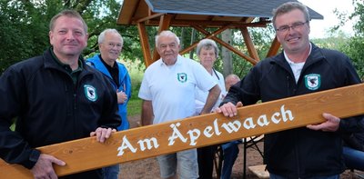 Vereinschef Ingo Claus (rechts) hat gestern mit Christian Meyer (links) das Schild für den Rastplatz "Am Äpelwaach" (Am Äppelweg) angebracht. Wolfgang Winkler (3. v .l) und Klaus Böhm (2. v. l.) haben sich um die mit Musik der Oelsnitzer Blasmusikanten hinterlegten QR-Codes gekümmert. 