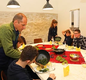 Schulleiter Ingo Weidhaas teilt den sanierten Räumen in der Gräfenmühle ein gemeinsam gekochtes Essen aus. 