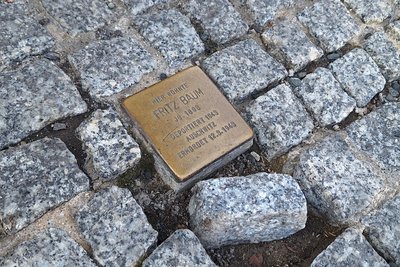 Ein Stolperstein in der Kesselgasse 1a erinnert vor der Bäckerei Möbius an den Freiberger Fritz Baum, der 1943 aus Berlin nach Auschwitz deportiert wurde. Er wurde vermutlich noch am Tag der Ankunft seines Transports von den Nazis vergast. Auch sein Name ist im Online-Archiv der „Arolsen Archives“ online zu finden.