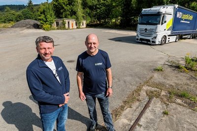 Auf diesem Gelände nahe am Hauptsitz plant Geschäftsführer Mike Purkart - hier im Bild mit Fuhrparkleiter Sven Neubert (r.) - eigentlich ein neues Logistikzentrum. Doch die explodierenden Strom- und Gaspreise verursachen eine Mehrbelastung in Millionenhöhe, die sogar gänzlich die Produktion in Niederschmiedeberg gefährden. 