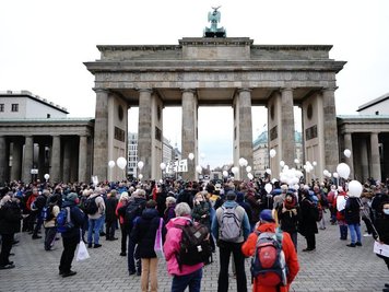             Teilnehmer einer Demonstration gegen die Corona-Einschränkungen der Bundesregierung stehen vor dem Brandenburger Tor.