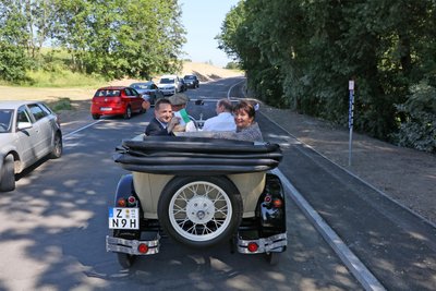 Bürgermeister Tino Obst, die CDU-Landtagsabgeordnete Kerstin Nicolaus und Landrat Christoph Scheurer auf dem Beifahrersitz fuhren das fertiggstellte Straßenstück in einem Oldtimer ab.