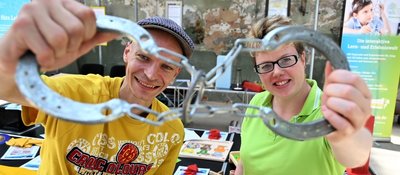 Wie bekommt man diesen Ring aus den beiden miteinander verketteten Hufeisen? Diese Knobelaufgabe stellen Annelie Weiß und Florian Rau von der Stollberger Lern- und Erlebniswelt "Phänomenia" bei der "Makers United" dem Publikum.
