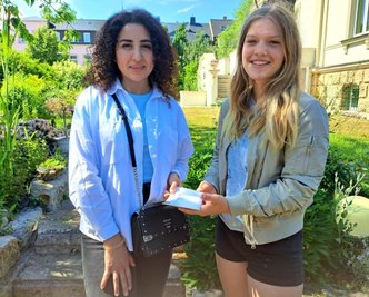 Alvina Andriiasova (li.) hat von Amelie Neuber eine Geldspende der Schüler der Klasse 7.1 des Freiberger Schollgymnasiums erhalten.