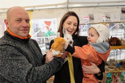Mal ein richtiges Kaninchen streicheln: Auch die kleine Elina (2), hier gehalten von ihrer Tante Anna Brix, nutzte auf dem Ostermarkt in Schwarzenberg die Gelegenheit. Ermöglicht hatte das der Rassekaninchenzüchterverein Bermsgrün -hier Marcel Lebelt - bei einer kleinen Ausstellung. 