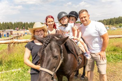 Bei Kathrin Schröter (vorn) konnten Gäste auf Pony „Blacky“ über die Wiese reiten. Das ließen sich die Zwillinge Alina (vorn) und Hannah nicht entgehen. Sie waren mit ihren Eltern Franziska Schneider und Patrick Saalfrank aus Chemnitz nach Geyer gekommen.