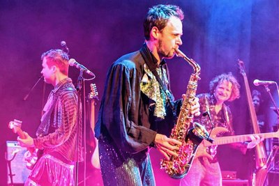 Jakob Widerin von Blank Manuskript mit Glitzeroutfit und Jazz-Saxofon.