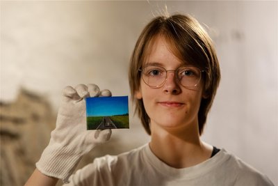 Emily Breite hält das nur sechs mal acht Zentimeter große Bild „Wegbegleiter“ von Lotta Seifert (17) aus Chemnitz in der Hand. Die Malerei in Acryltechnik erhielt einen Hauptpreis.