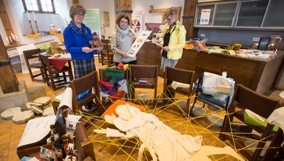 Hildburg Hecker, Brigitta Werner und Katharina Weigelt (v. l.) verpassen der Sonderausstellung "Ich begleite dich" im Bergmagazin den letzten Schliff.