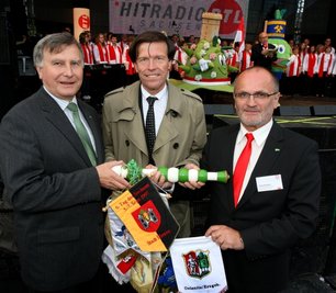
              <p class="artikelinhalt">Oelsnitz geht, Kamenz kommt: Bei der Abschlussveranstaltung nahe dem Rathaus übergab Bürgermeister Hans-Ludwig Richter (l.) im Beisein von Kuratoriumspräsident Matthias Rößler den mit 19 Stadtflaggen geschmückten Staffelstab an seinen Kamenzer Amtskollegen Roland Dantz (r.). </p>
            