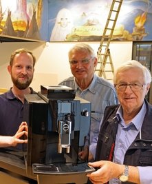 Erich Homilius (Mitte) und Wolfgang Hallmann vom Verein Silberbüchse übergeben an Mitarbeiter des Hauses Marian Bertz (li.) eine neue Kaffeemaschine . 
