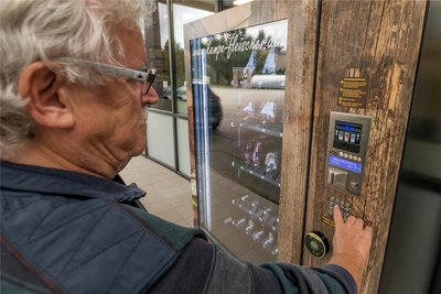 An der Olbernhauer Total-Tankstelle bedient ein Kunde den Automaten der Fleischerei Kempe.