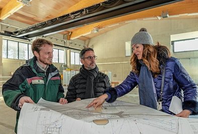 Heike Krenkel, Leiterin der Sib-Niederlassung Zwickau (rechts), beim Termin mit dem Landtagsabgeordneten Sören Voigt (CDU) und Toni Eßbach, Leiter der Ausbildungsstätte, in der Maschinenhalle für die Forsttechnik.