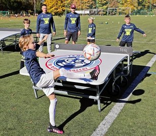 Die Kinder des Oberlungwitzer Trainingscamps probierten sich auch an Sportarten wie "Teqball" aus. Die beiden Trainer Tibor Szèkely (hinten links) und Marcel Sonntag beobachteten das Geschehen. 