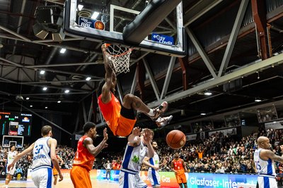 Jeff Garrett hängt nach einem Dunking am Korb. Er gewann mit den Niners Chemnitz das erste Spiel des Jahres gegen Frankfurt.