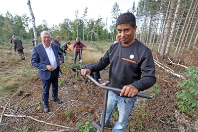 Shayak Majumde aus Indien studiert an der TU Bergakademie Grundwassermanagement und beteiligt sich an der Pflanzaktion. Im Hintergrund Unirektor Klaus-Dieter Barbknecht.