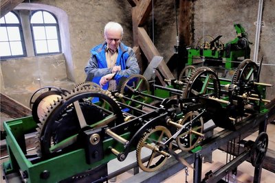 Pfarrer Andreas Alders freut sich, dass die Turmuhr der Peter-Paul-Kirche noch vor Weihnachten in Betrieb gehen konnte. Vorn die Steuerung des Schlagwerkes und hinten rechts das Uhrwerk selbst.
