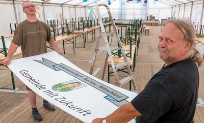 Uwe Herzog (rechts) und Philipp Auerswald vom Bauhof Gornau haben das Festzelt auf dem Dittmannsdorfer Sportplatz eingeräumt und geschmückt. 