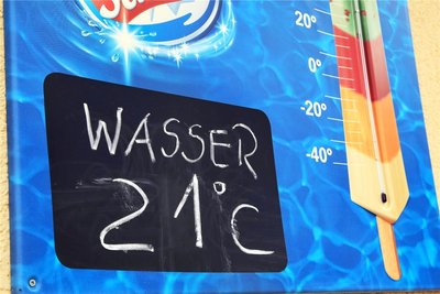 Auf der Tafel steht es weiß auf schwarz. Das Wasser ist 21 Grad warm und weist damit die höchste Temperatur der Freibäder im Göltzschtal auf.