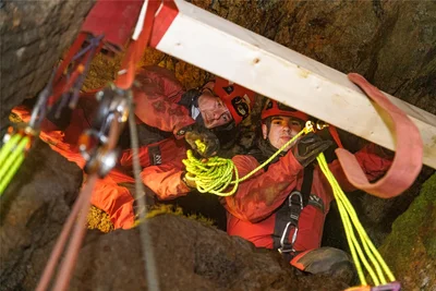 Im ersten Versuch installierten die Retter – hier Robert Müller (l.) und Maximilian Wolf – oberhalb der Treppe einen Balken, um daran die Ankerpunkte für die Seiltechnik zu befestigen.