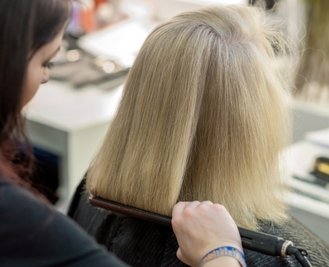 Schritt 2: Make-up-Artistin Ennie Hafemann glättet das krause Haar. Das soll das Gesicht strecken.