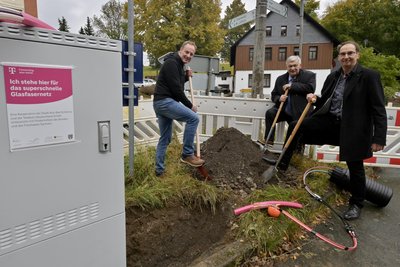 Symbolischer Baustart für den Glasfaserausbau in Alberoda: Marco Nobis (l.) und Hendrik König (r.) von der Telekom mit Aue-Bad Schlemas Oberbürgermeister Heinrich Kohl beim Spatenstich.