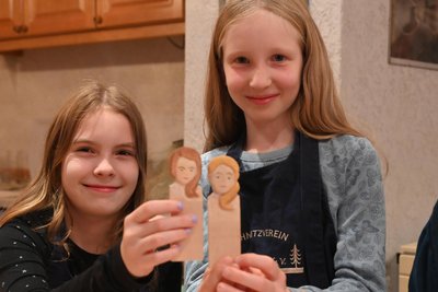 Josefine und Jule (r). zeigen ihre Porträt-Schnitzversuche.