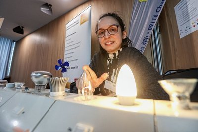 Julia Weiß von den Solaris Jugend- und Umweltwerkstätten zeigt interessierten Besuchern, dass eine 25 Watt Glühlampe geringer leuchtet als eine LED Lampe mit 3 Watt Stromverbrauch.