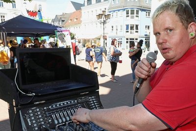 Veranstalter Stefan Rubey mit Mikro am Mischpult.