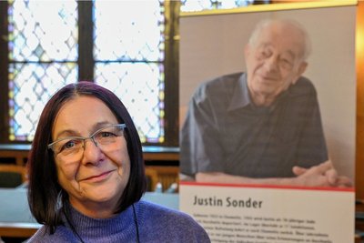 Kerstin Claus, Tochter von Justin Sonder, vor einem Foto ihres 2020 verstorbenen Vaters. Die Idee eines Denkmals in Form einer Bank gefällt ihr. Gut sei, dass der Vater nicht auf einen Sockel gehoben werde. 