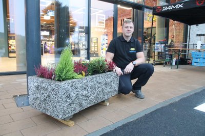 Steve Höfer hat den Pflanzkübel des ehemaligen Kunststeinwerks vor dem Markt platziert.