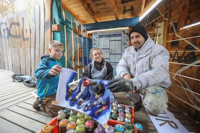 Niels (9) und Emma (10) aus der vierte Klasse der Grundschule Rußdorf besprühen unter Anleitung von Künstler Benjamin Sprunk die Beobachtungsplattform am Großen Teich im Limbacher Teichgebiet.