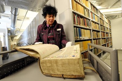 Bibliothekarin Sabine Schumann mit der restaurierten Eggestein-Bibel aus der Zeit um 1460, deren Leder-Einband aufgequollen war, im Magazin der Stadtbibliothek. Hier lagern neben besonders wertwollen auch selten nachgefragte Bücher, die zu schade zum Aussortieren sind.