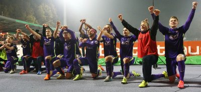 Die FCE-Profis mit gekreuzten Armen, die Schlägel und Eisen symbolisieren sollen, vor der Fankurve im Erzgebirgsstadion.