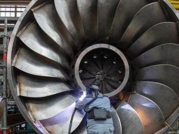  
          Ein Angestellter in einer Maschinenbaufirma arbeitet an einer Wasserturbine.