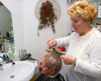 Christa Rosin schneidet Elfriede Thalwitzer die Haare