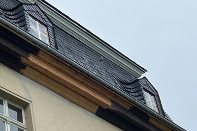 Das ist aus Bauabschnitt eins noch zu erledigen: Teile des unteren Simskastens am Rittergut Bösenbrunn sind bisher ungestrichen, Fenster im Dach zunächst durch Folie-Provisorien geschlossen.