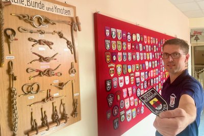 Mehr als 170 Wappen von Wehren aus Deutschland und auch Tschechien sind an die Wand im Nossener Depot gespickt. Vize-Wehrleiter Christian Weigelt zeigt ein Emblem der Münsterer Wehr aus Nordrheinwestfalen am anderen Ende der Bundesrepublik. „Diese symbolisieren die große Kameradschaft über Stadt- und Landesgrenzen hinaus“, sagt Weigelt. Die Wappen werden beispielsweise bei Treffen und Weiterbildungen getauscht.