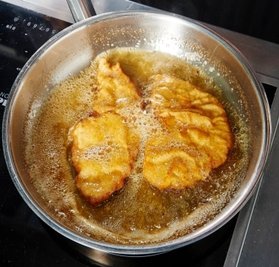 Unter gelegentlichem Schwenken werden die Schnitzel ausgebacken.