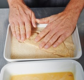 Erst das Fleisch durch die Eisahne ziehen, dann in den Bröseln wenden.
