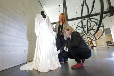 Museumspädagogin Franziska Waldmann und die Wissenschaftliche Mitarbeiterin Katrin Färber setzen das Kleid in Szene.