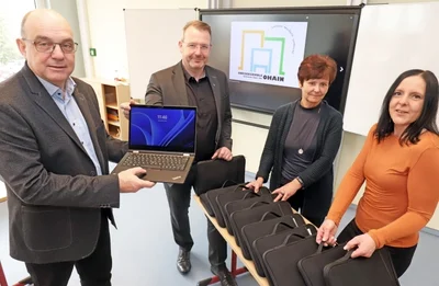 Schulmitarbeiterin Susann Glöckner (v. r.), die stellvertretende Schulleiterin Ute Baumgart, Freibergs Oberbürgermeister Sven Krüger und Schulleiter Jens Gernegroß nehmen die neuen Notebooks für die Lehrer der Ohain-Oberschule in Augenschein. 