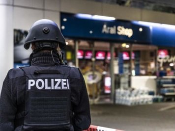 Ein Polizist steht vor der Tankstelle in Idar-Oberstein, an der ein Angestellter von einem Mann erschossen worden ist.